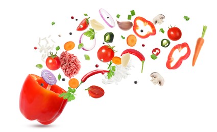 Image of Stuffed pepper recipe. Fresh ingredients falling into bell pepper on white background