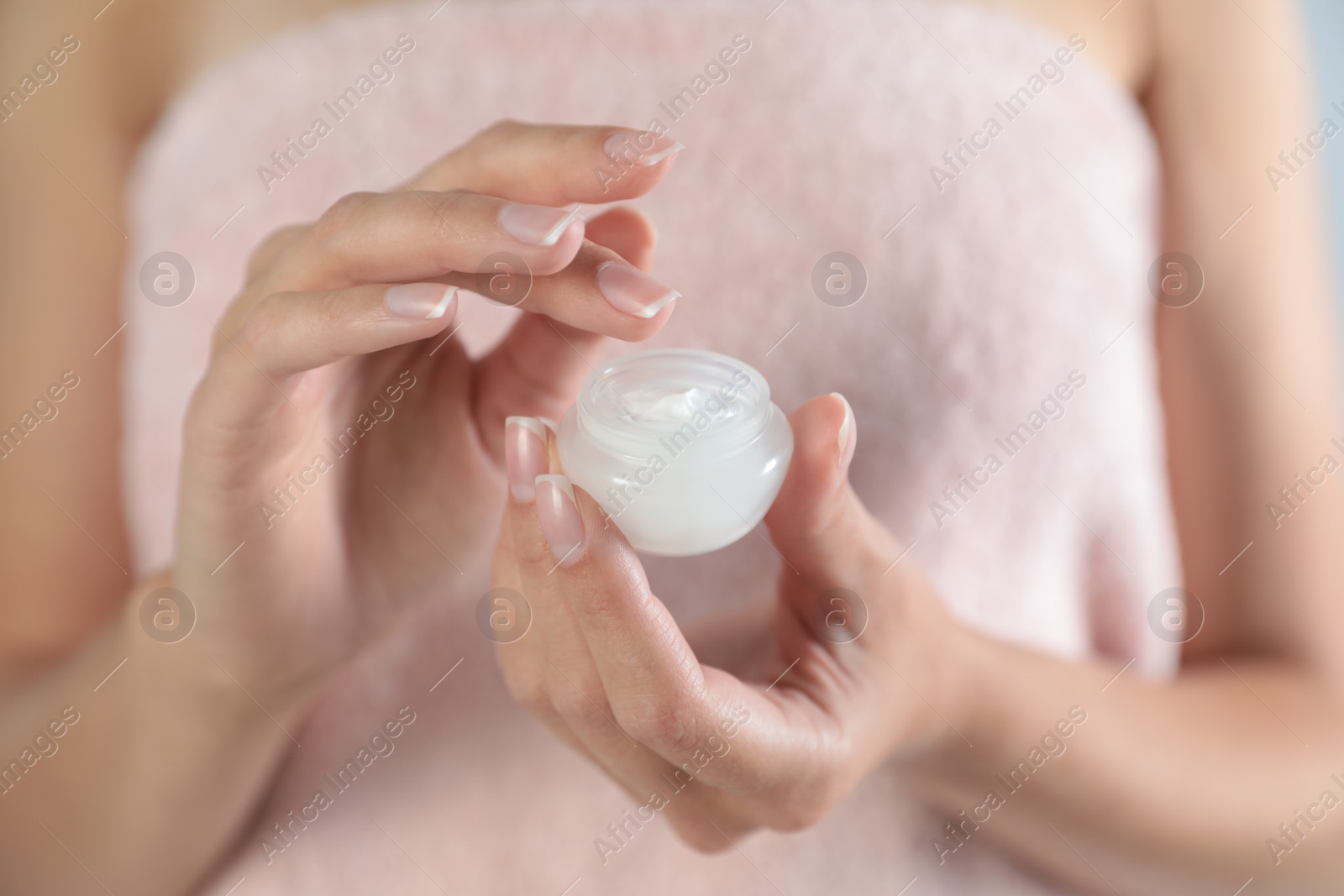 Photo of Young woman holding jar of cream, closeup