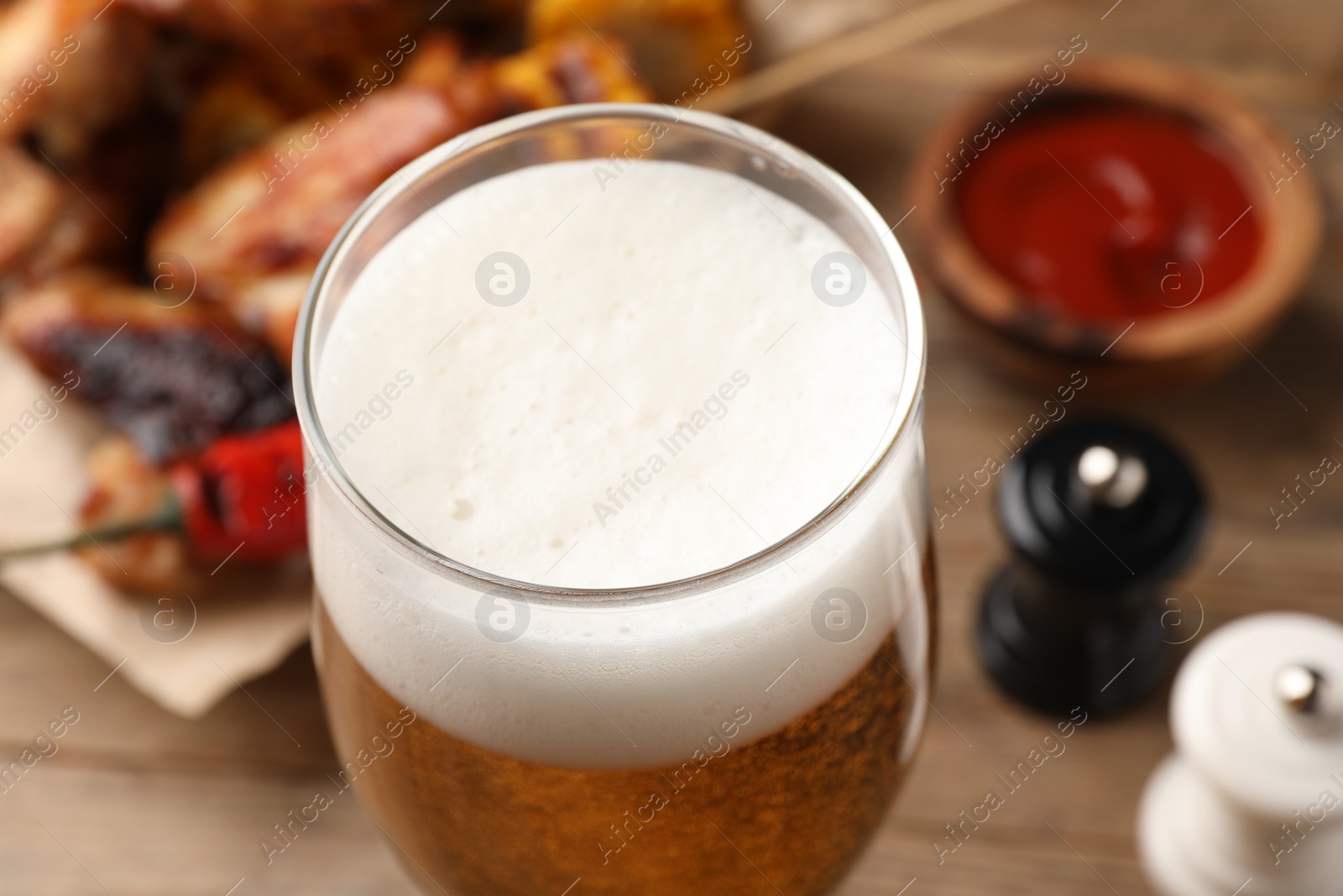 Photo of Glass of tasty beer on table, closeup view