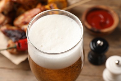 Photo of Glass of tasty beer on table, closeup view