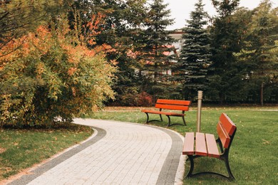Winding pathway with beautiful bushes and benches in park