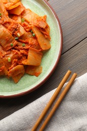 Delicious kimchi with Chinese cabbage served on wooden table, flat lay