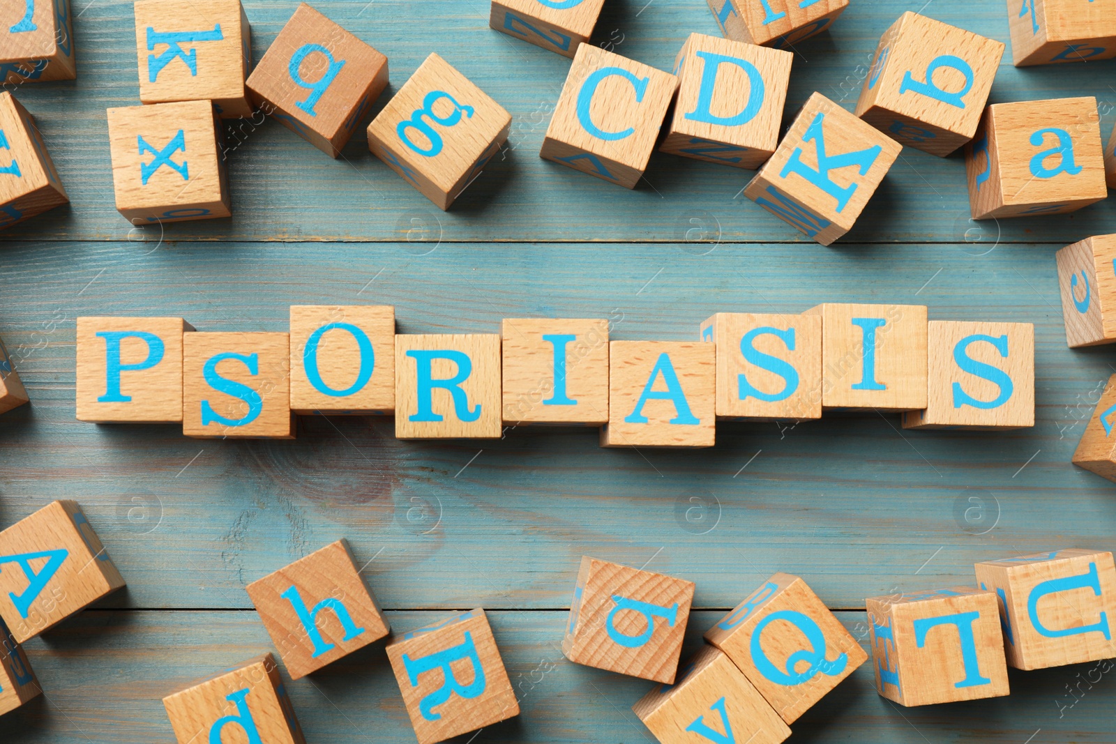 Photo of Word Psoriasis made of cubes with letters on wooden table, flat lay