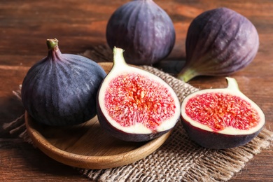 Photo of Plate with fresh ripe figs on wooden background. Tropical fruit