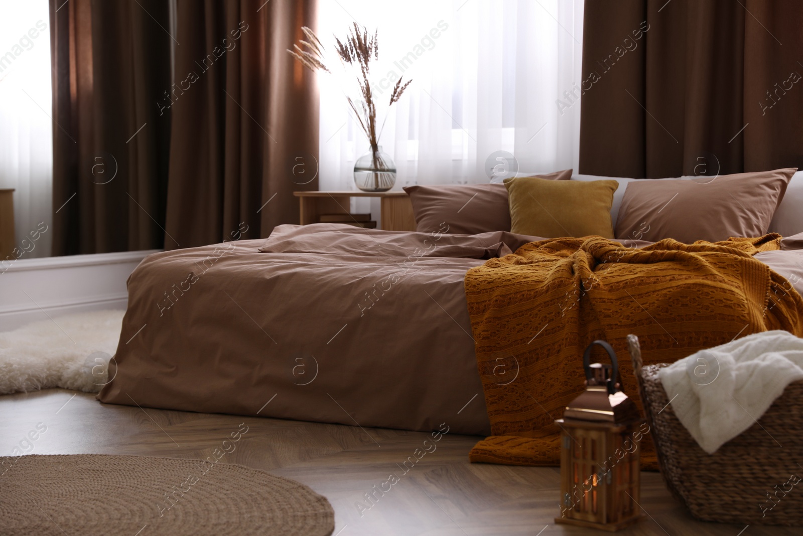 Photo of Bed with brown linens in stylish room interior