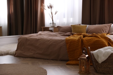Bed with brown linens in stylish room interior