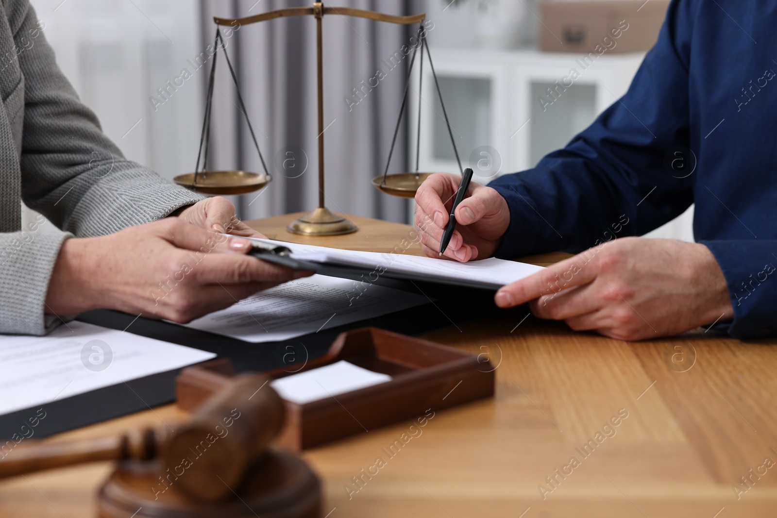 Photo of Man signing document in lawyer's office, closeup