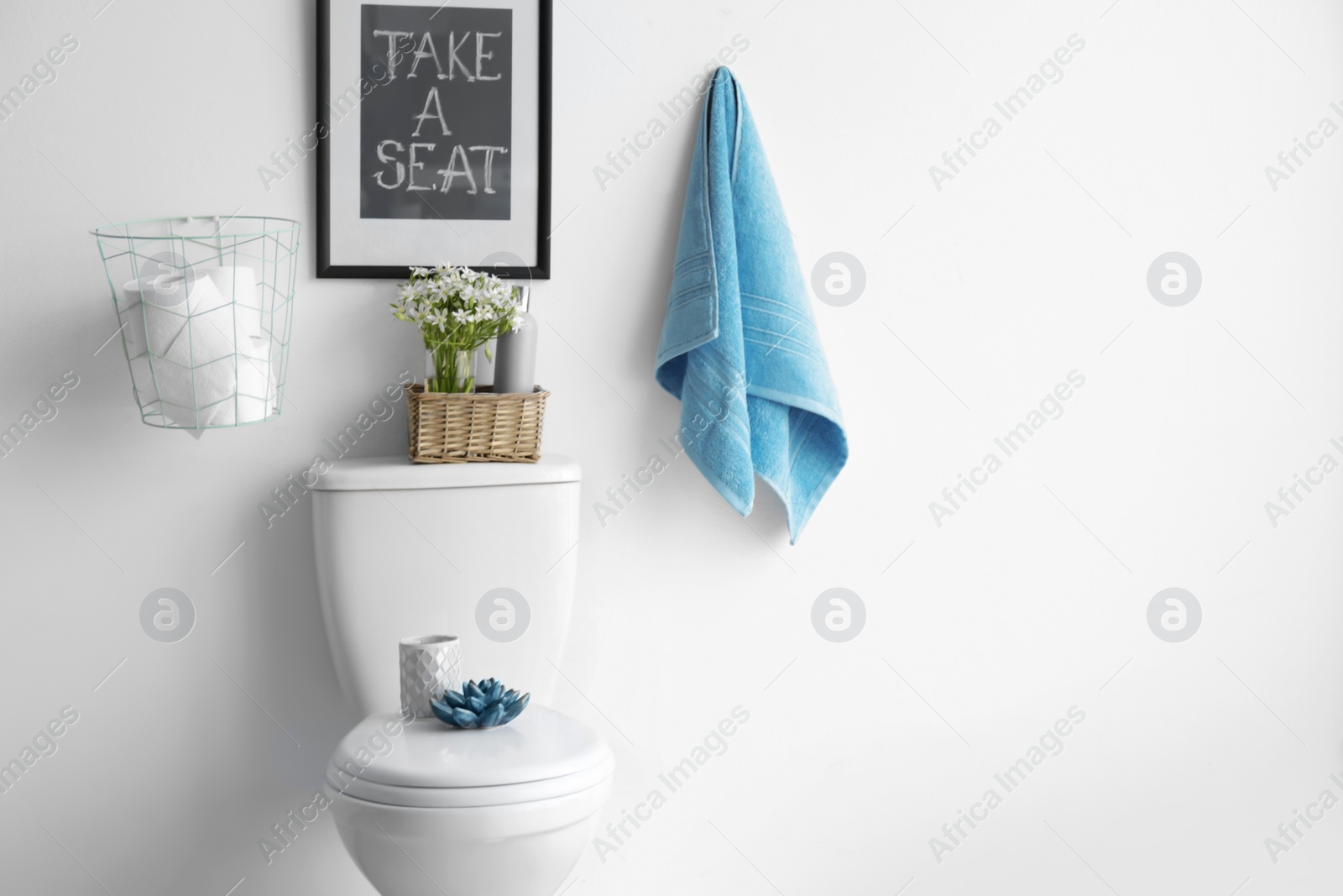 Photo of Decor elements, necessities and toilet bowl near white wall, space for text. Bathroom interior