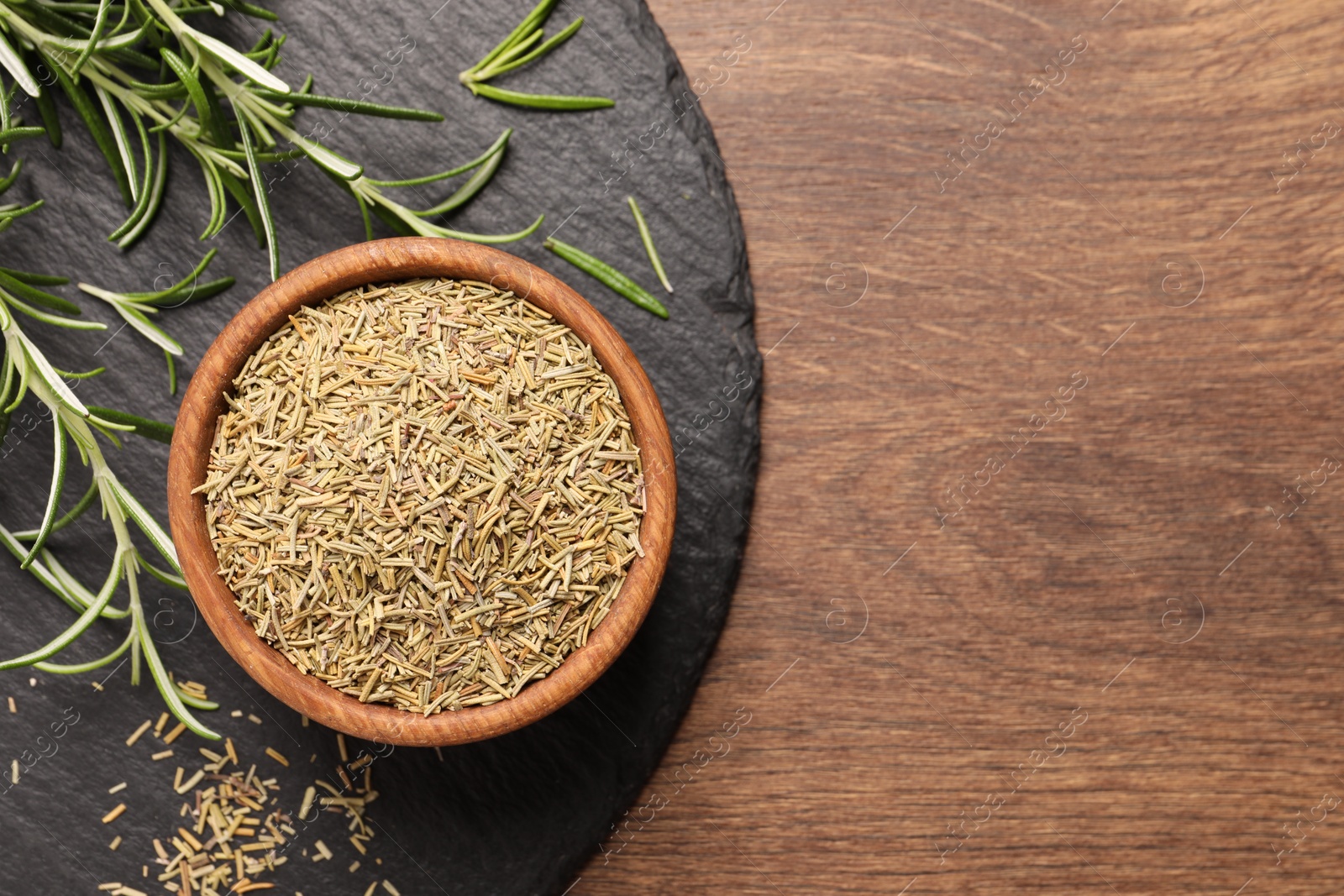 Photo of Fresh and dry rosemary on wooden table, top view. Space for text