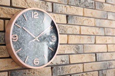 Stylish clock on brick wall. Time concept