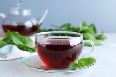 Fresh tea with mint on light table