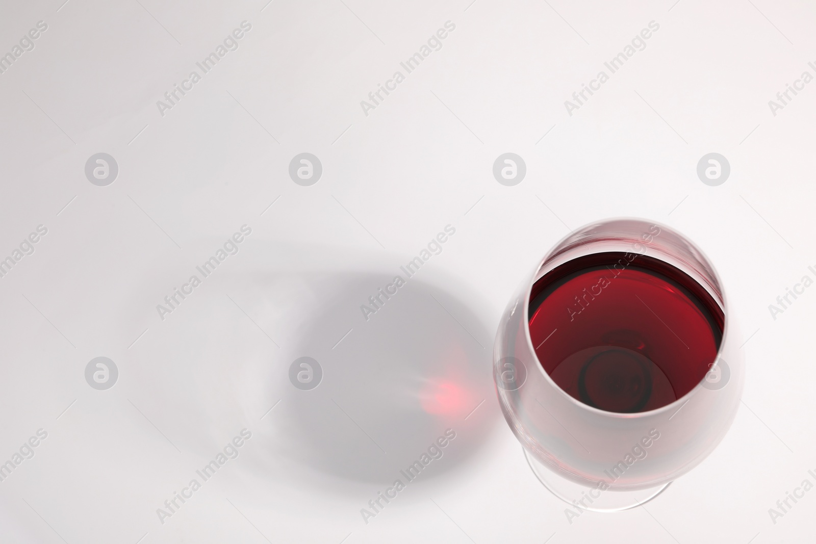 Photo of Tasty red wine in glass isolated on white, above view