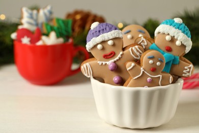 Delicious homemade Christmas cookies in bowl on white wooden table against blurred festive lights. Space for text