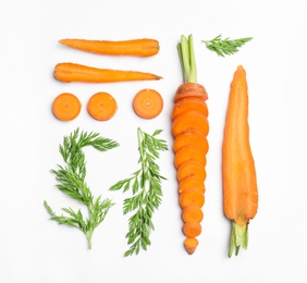 Cut carrots and leaves isolated on white, top view