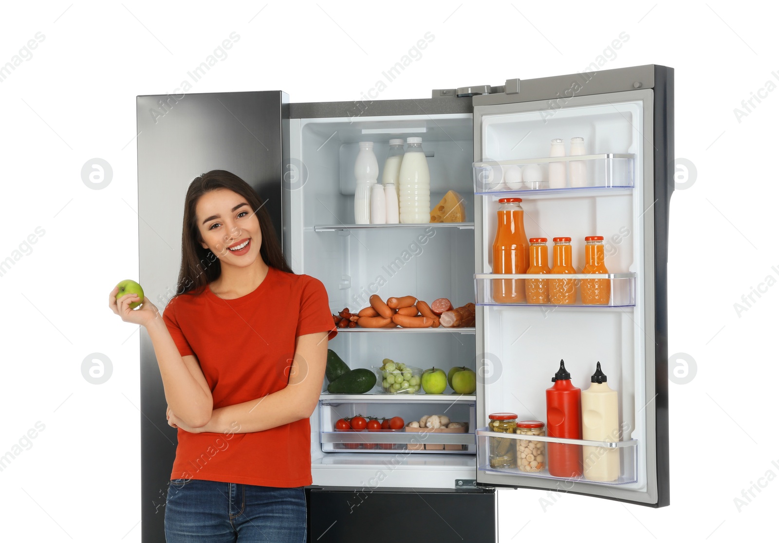 Photo of Young woman with apple near open refrigerator on white background