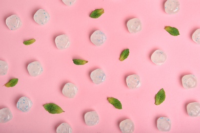 Flat lay composition with tasty mint candies and leaves on color background