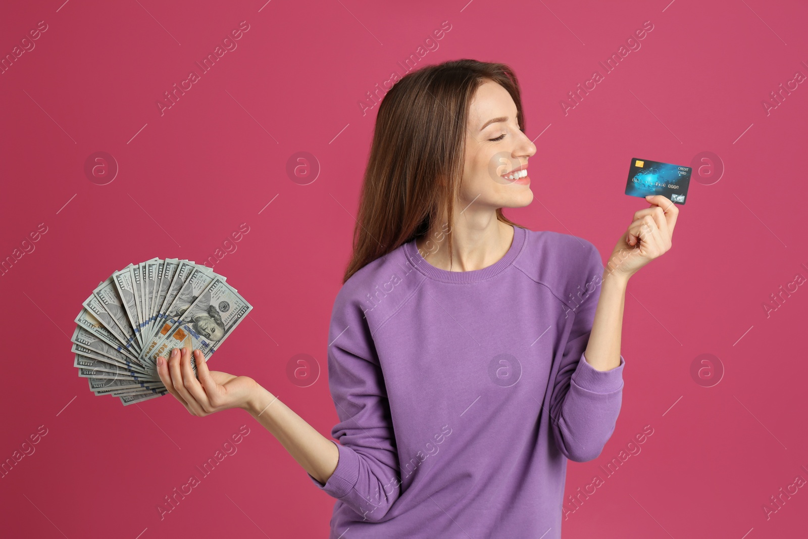 Photo of Happy young woman with cash money and credit card on pink background