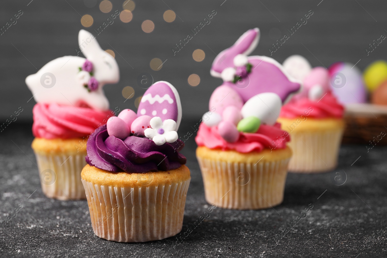 Photo of Tasty decorated Easter cupcakes on grey table