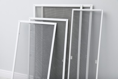 Photo of Set of window screens near light grey wall indoors