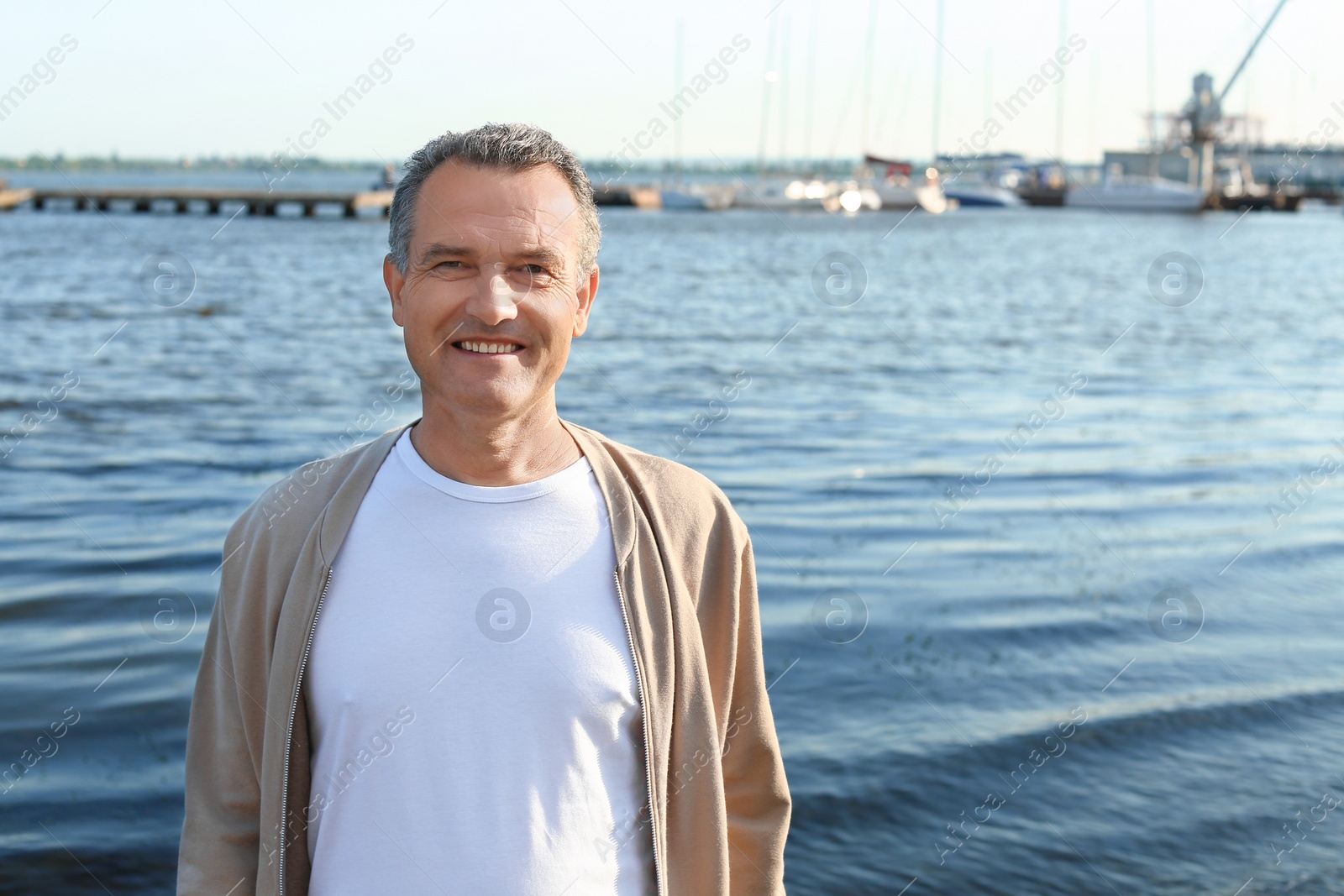 Photo of Male pensioner near river on sunny day. Space for text