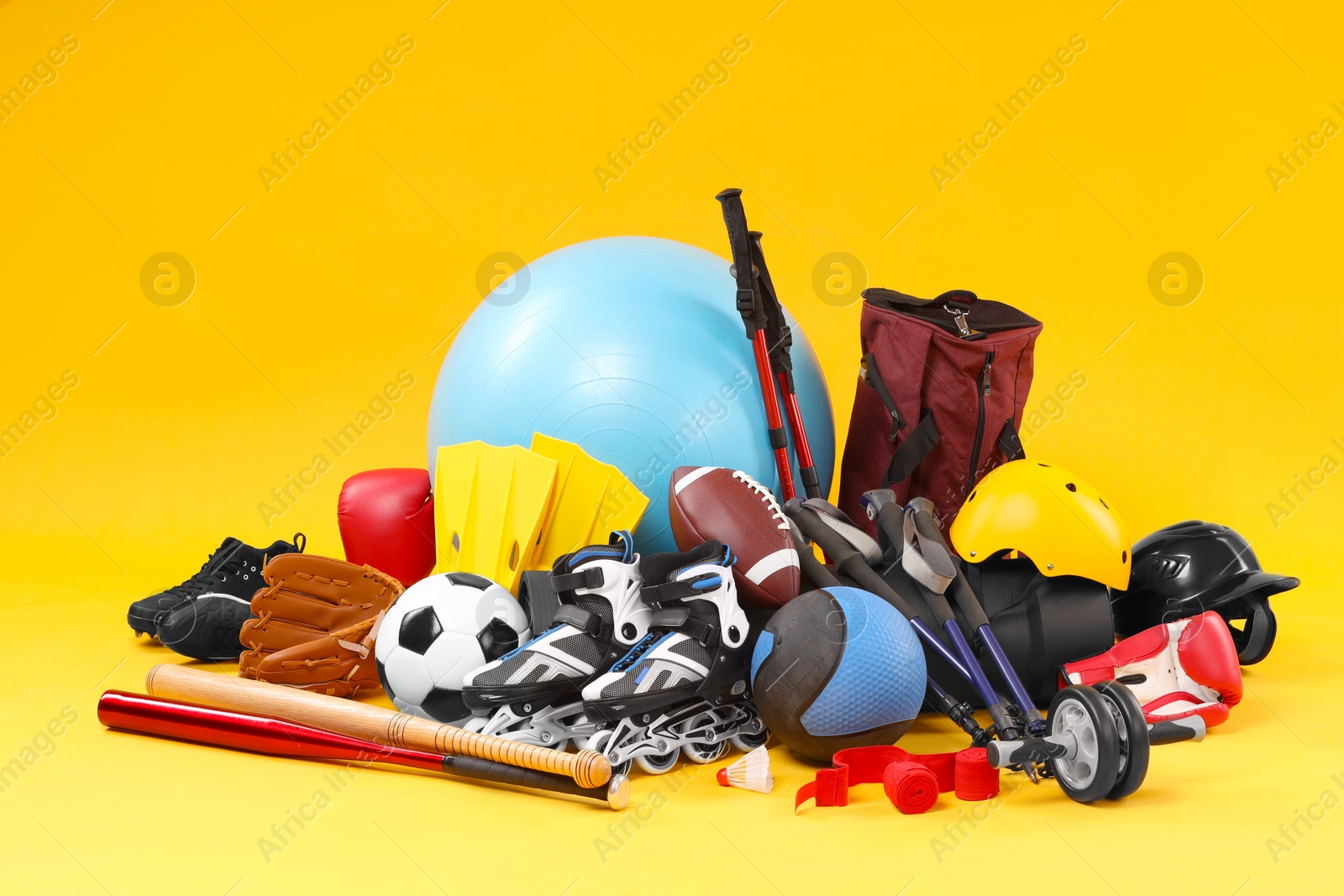 Photo of Many different sports equipment on yellow background