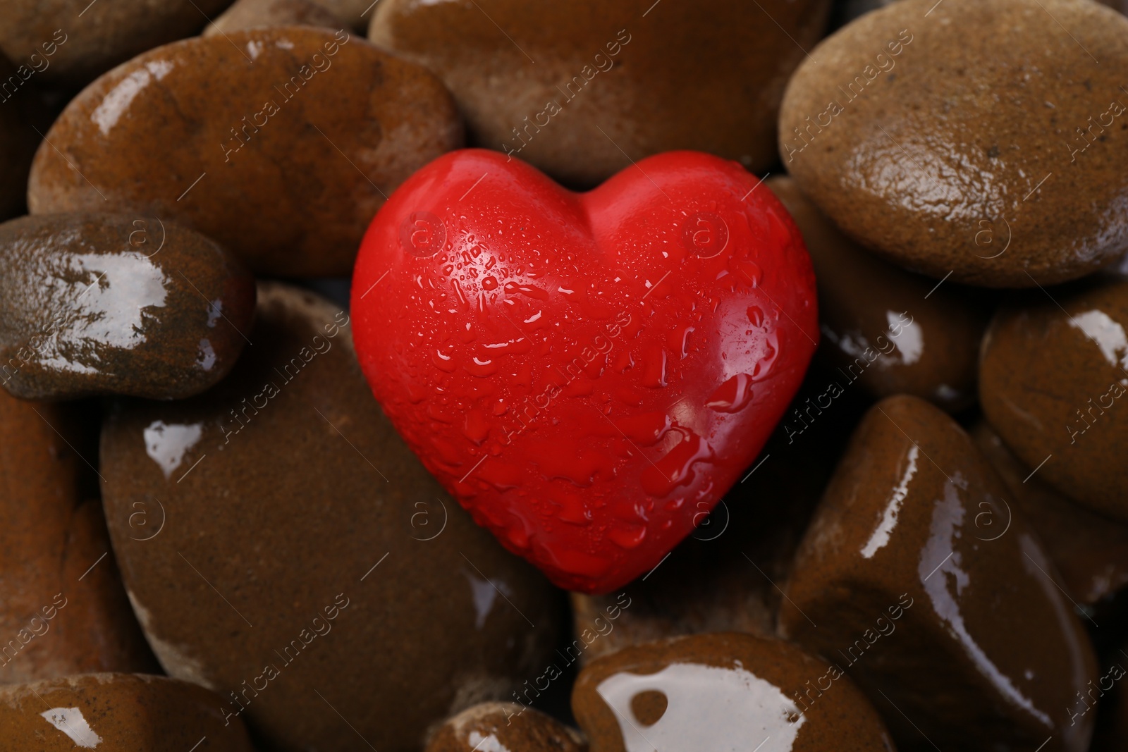 Photo of Red decorative heart on stones, closeup view