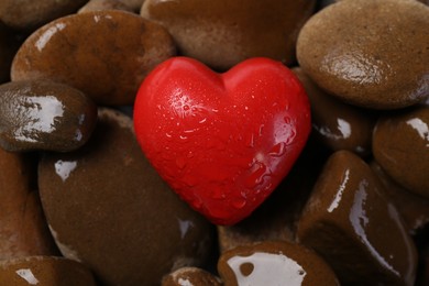 Photo of Red decorative heart on stones, closeup view