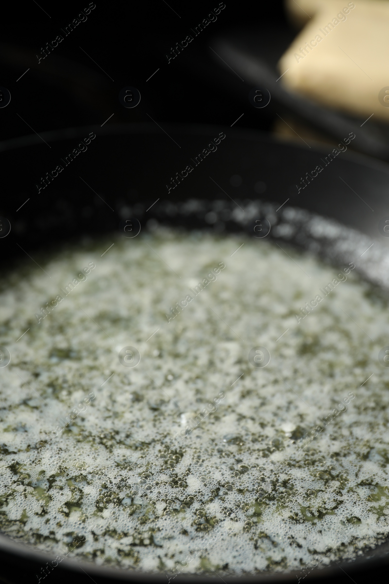 Photo of Melting butter in frying pan, closeup view