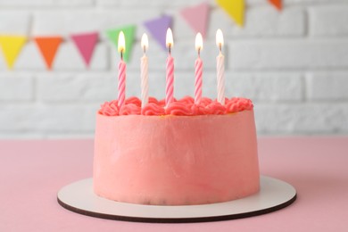 Photo of Cute bento cake with tasty cream and burning candles on pink table