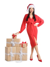 Photo of Woman in red dress and Santa hat with Christmas gifts on white background