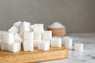 Refined sugar cubes on white marble table