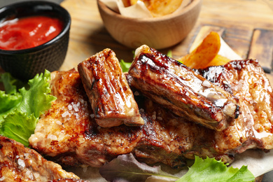 Delicious grilled ribs on board, closeup view