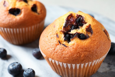 Photo of Muffins with blueberries on stone table, closeup view. Space for text