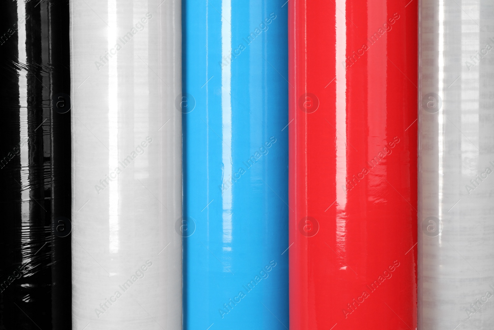 Photo of Different plastic stretch wrap films as background, closeup