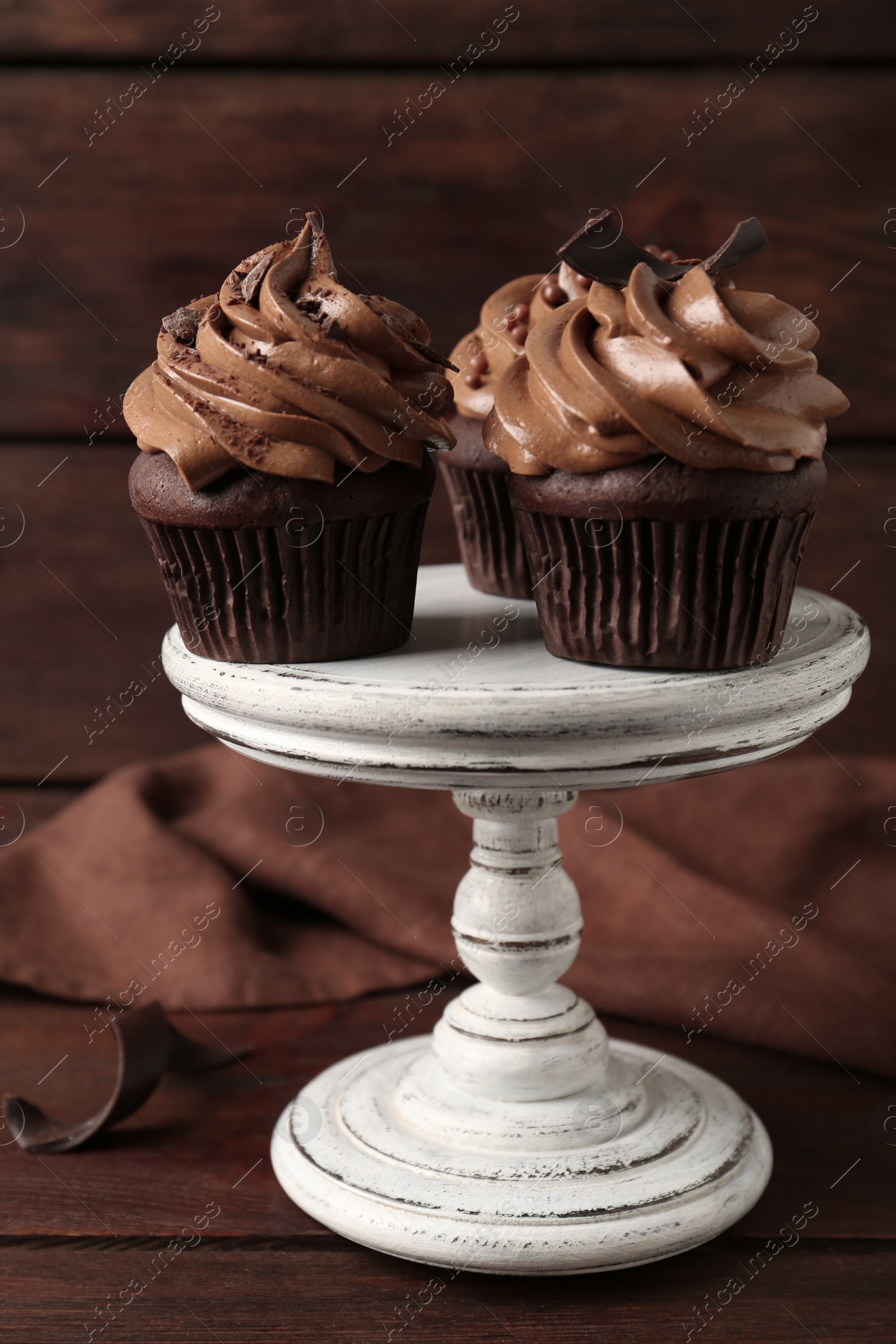 Photo of Delicious cupcakes decorated with cream on wooden table