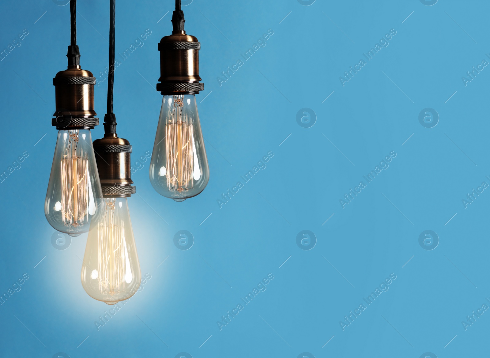 Image of Idea concept. Glowing light bulb among others on blue background, space for text 