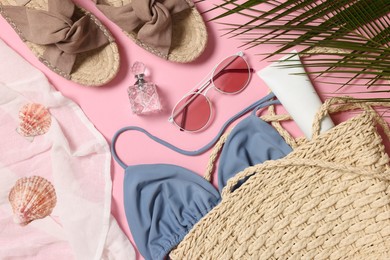 Photo of Flat lay composition with wicker bag and other beach accessories on pink background