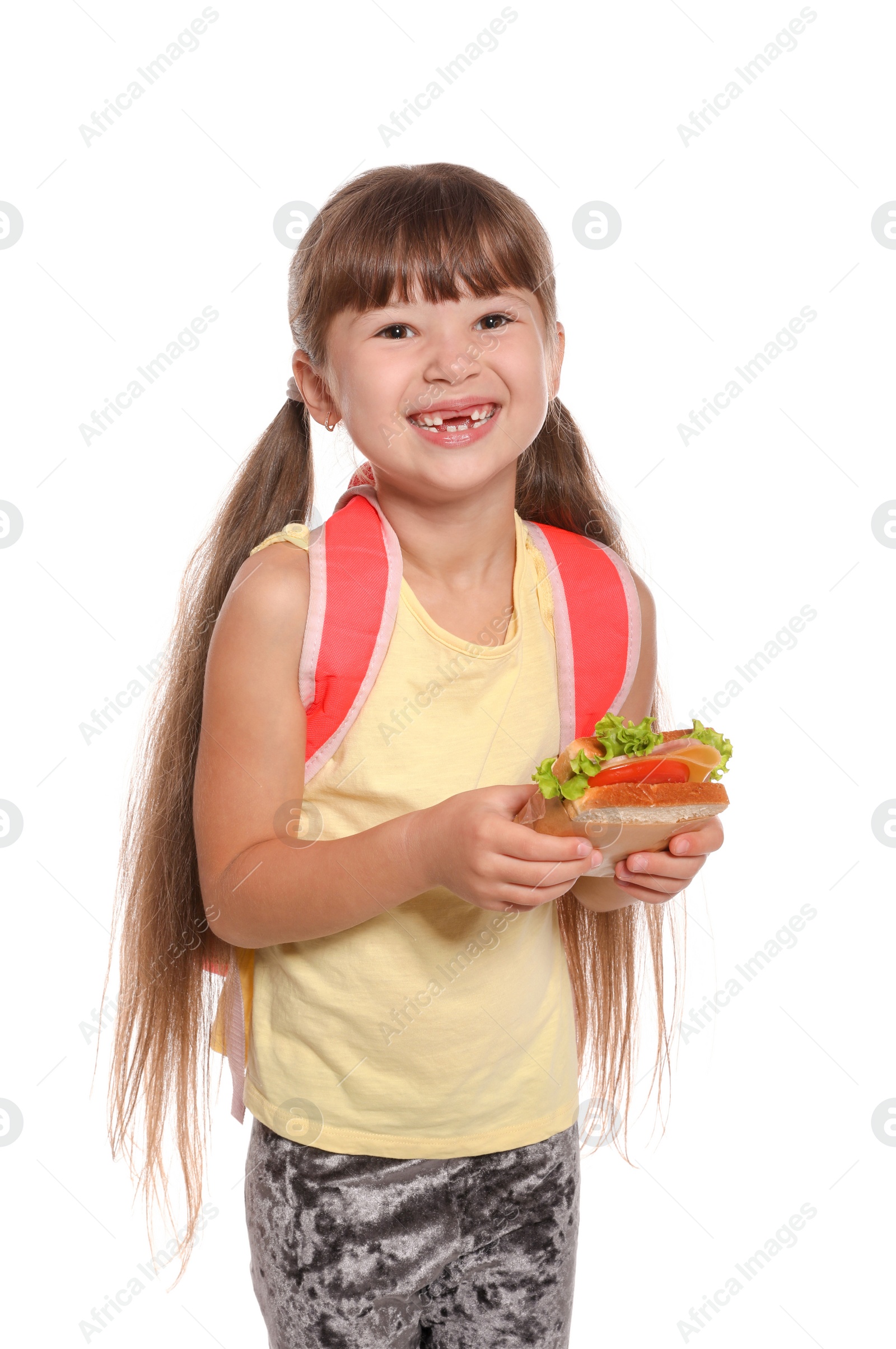 Photo of Schoolgirl with healthy food and backpack on white background