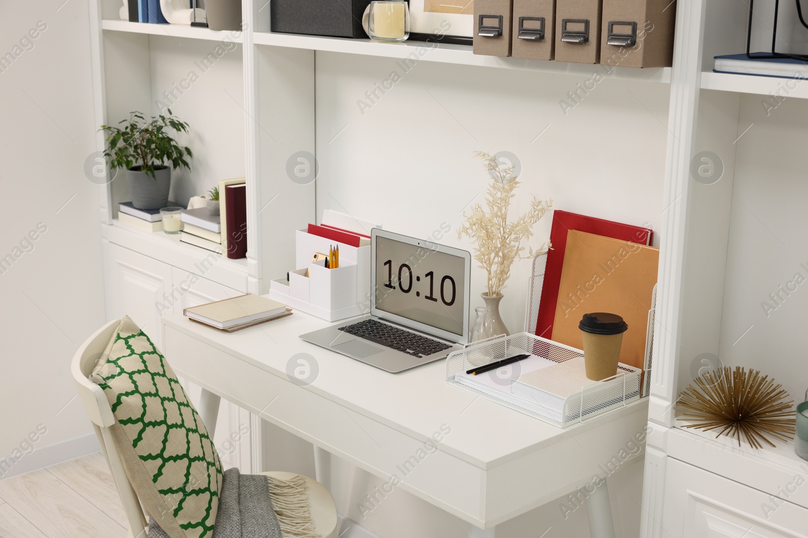 Photo of Cozy workspace with laptop on wooden desk at home