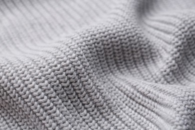 Grey knitted fabric as background, closeup view