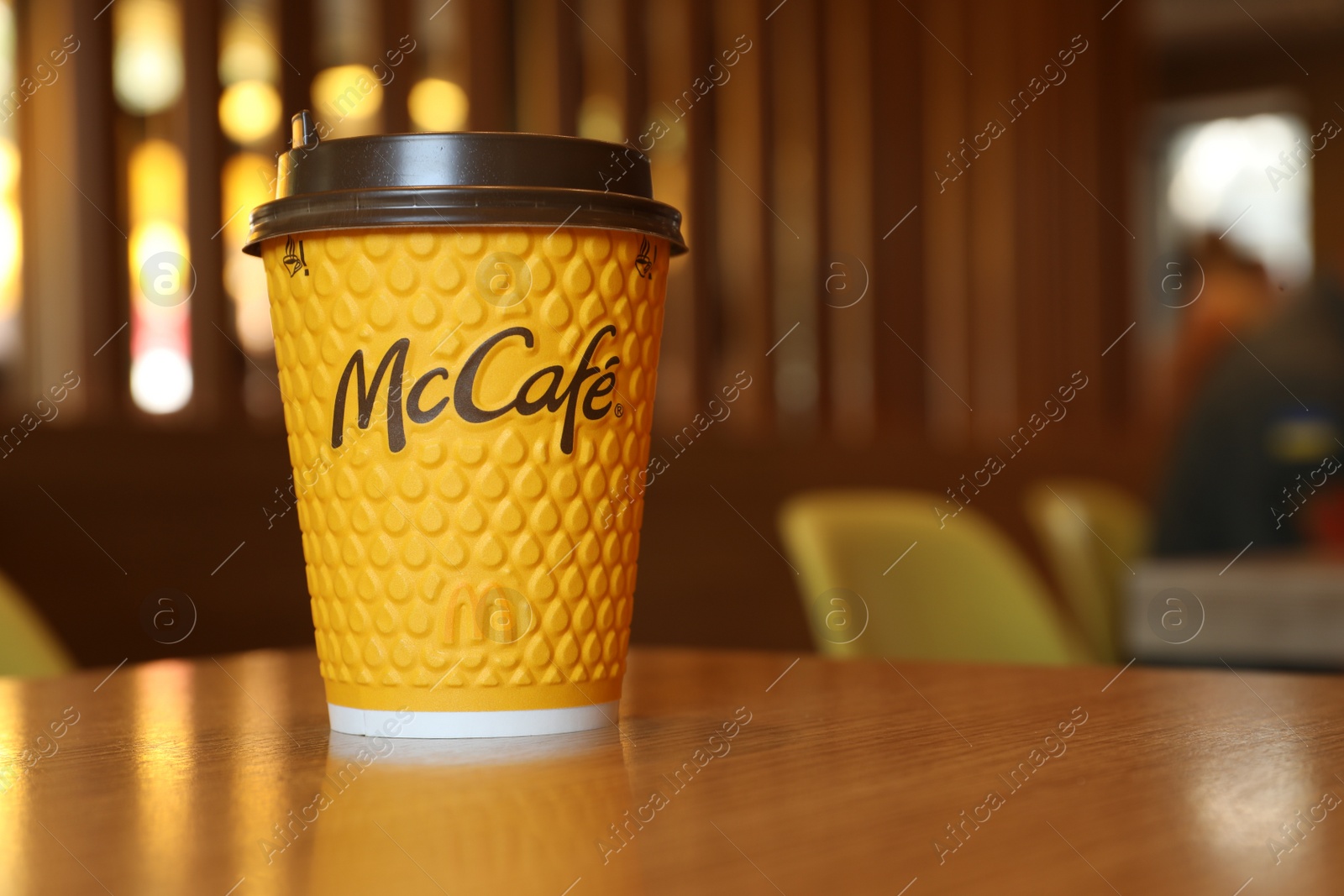 Photo of MYKOLAIV, UKRAINE - AUGUST 11, 2021: Hot McDonald's drink on table in cafe. Space for text