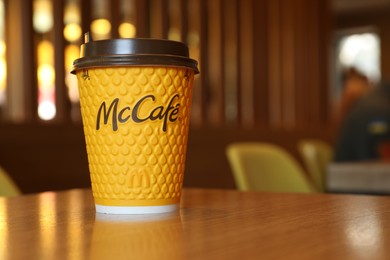 Photo of MYKOLAIV, UKRAINE - AUGUST 11, 2021: Hot McDonald's drink on table in cafe. Space for text