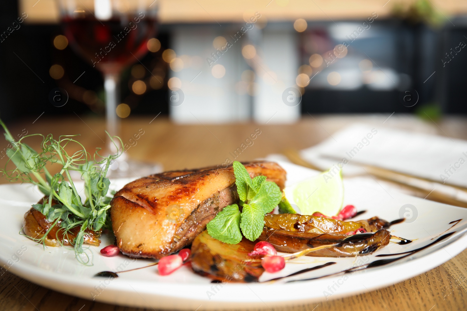 Photo of Delicious grilled duck breast served on wooden table indoors, closeup