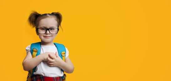 First time at school. Cute little child wearing glasses on yellow background, space for text. Banner design