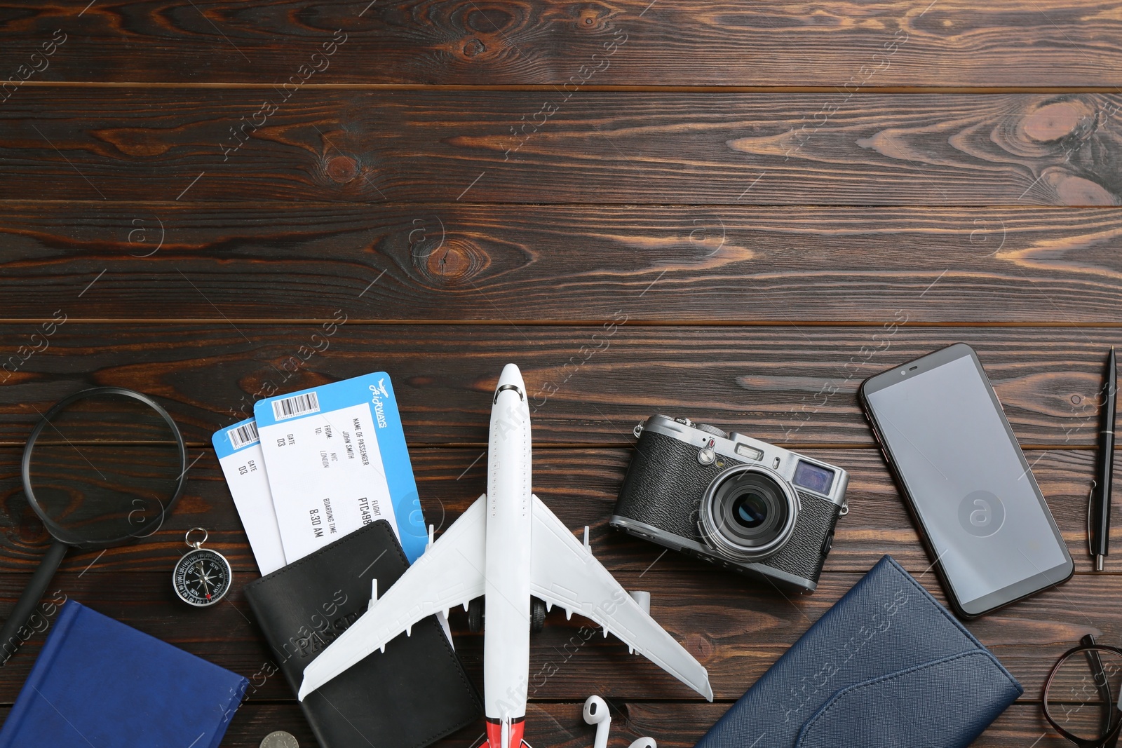 Photo of Flat lay composition with toy airplane and travel items on wooden background. Space for text