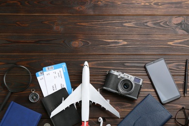 Photo of Flat lay composition with toy airplane and travel items on wooden background. Space for text