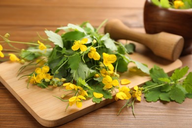 Celandine and board on wooden table, closeup