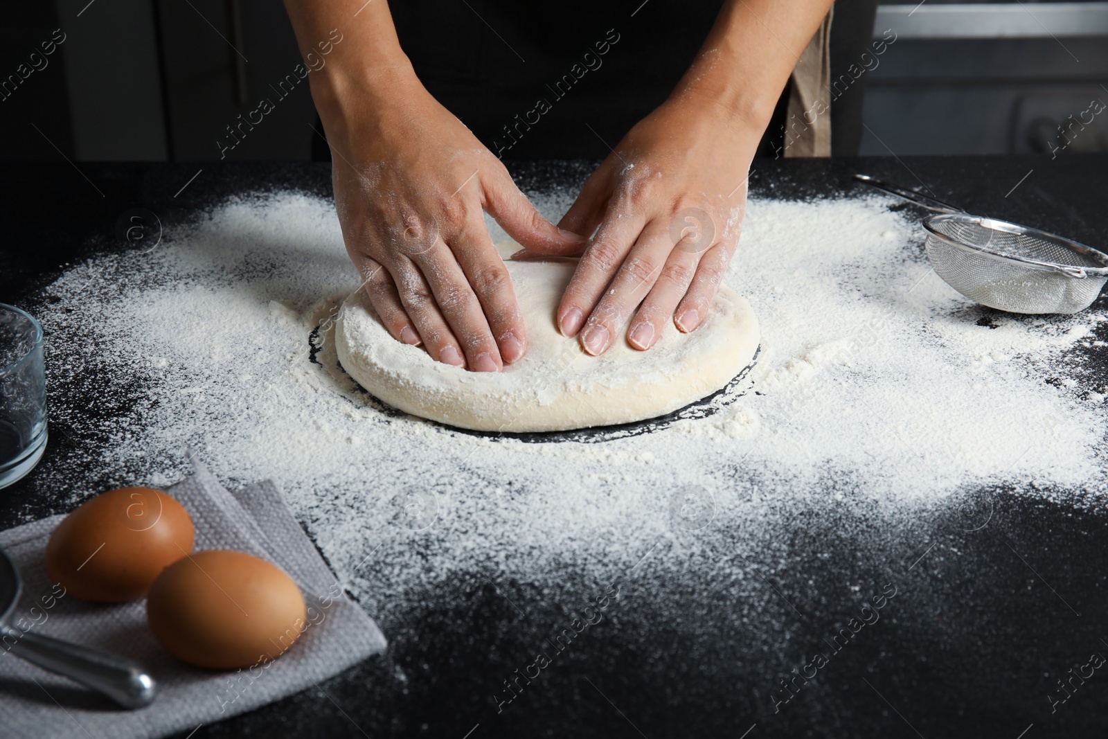 Photo of Woman making dough for pastry on table