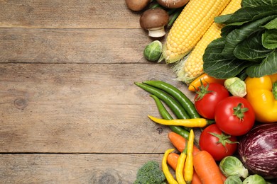 Photo of Different fresh vegetables on wooden table, flat lay. Space for text