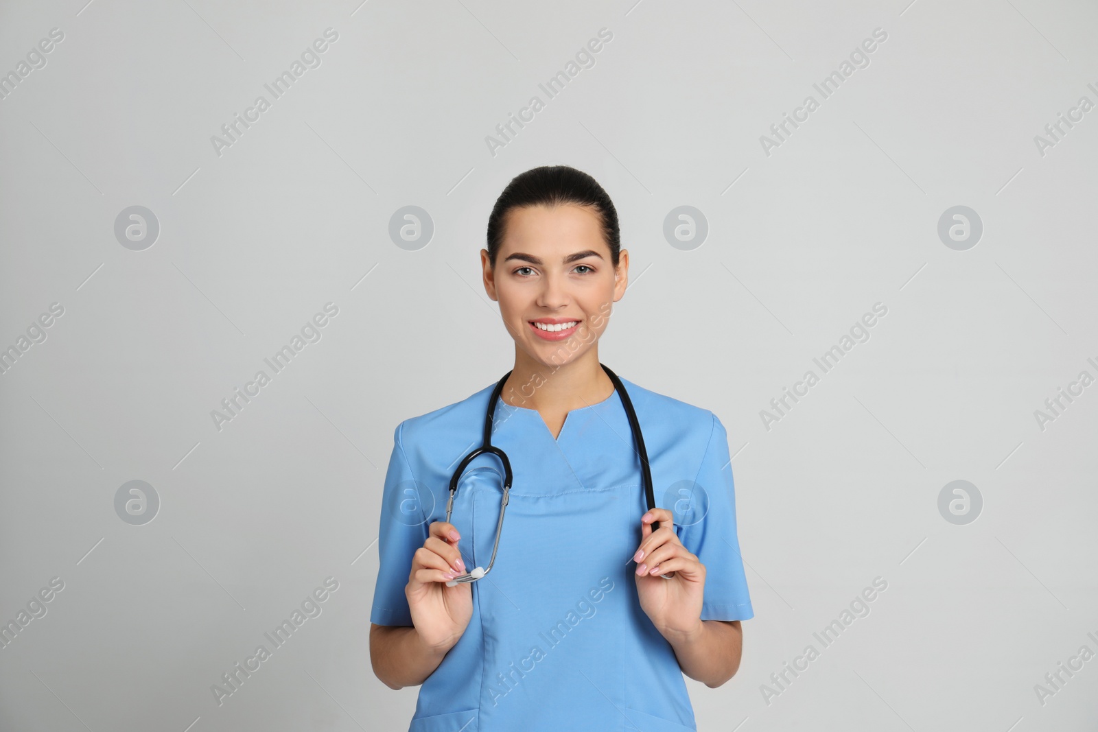 Photo of Portrait of young medical assistant with stethoscope on color background